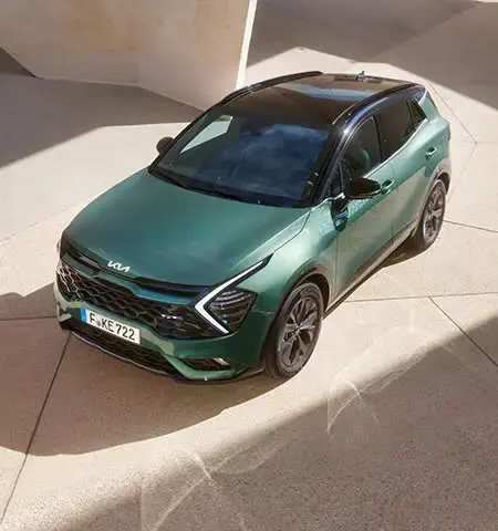 1-Ausstattungslinien-kia_sportag Kia Sportage in Grün auf modernem Pflaster fotografiert.