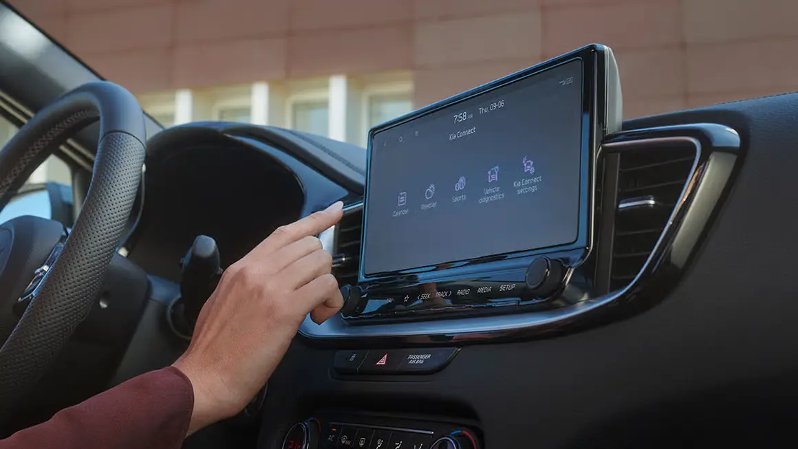 Eine Person bedient den Touchscreen im Innenraum eines Kia XCeed.