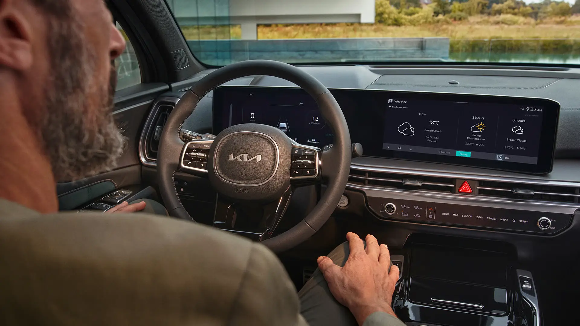 Fahrer im Innenraum eines Kia Sorento mit Blick auf das digitale Armaturenbrett.