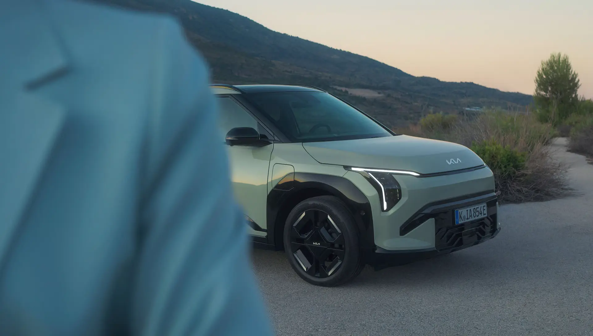 KIA EV3 in einer Landschaft bei Sonnenuntergang.