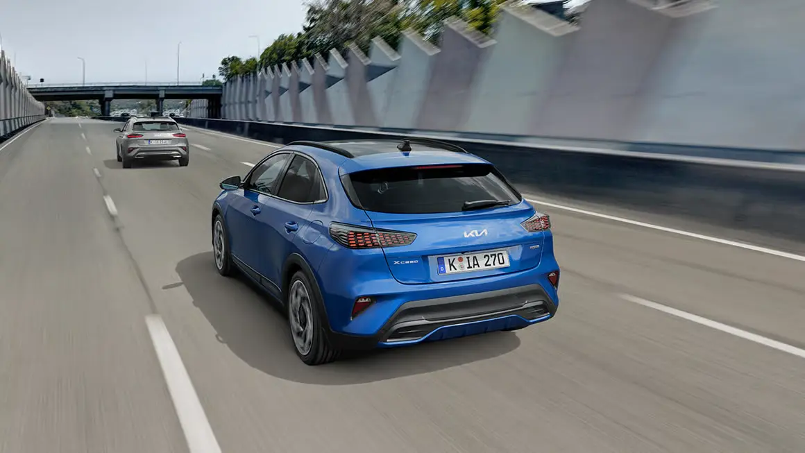 Ein blauer Kia XCeed fährt auf einer Autobahn.