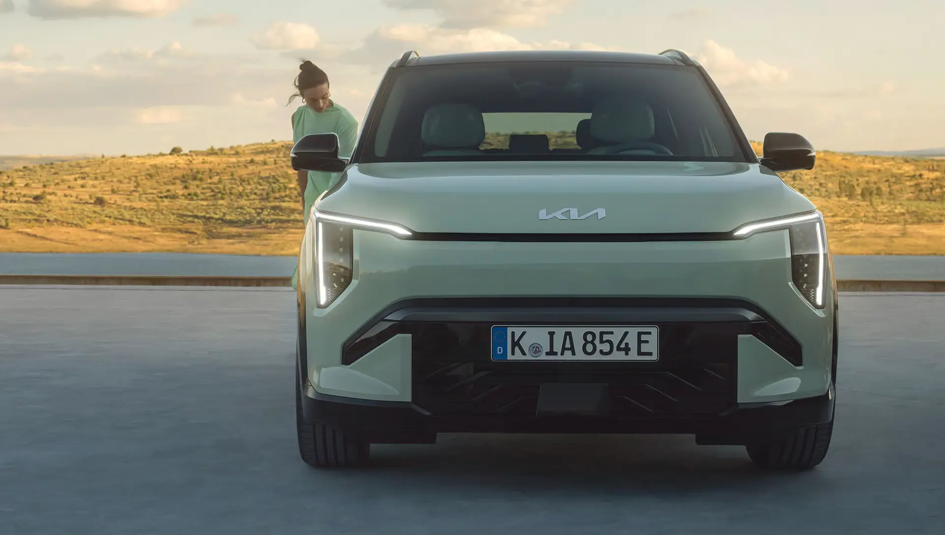 KIA EV3 in einer Landschaft mit einer Person im Hintergrund.