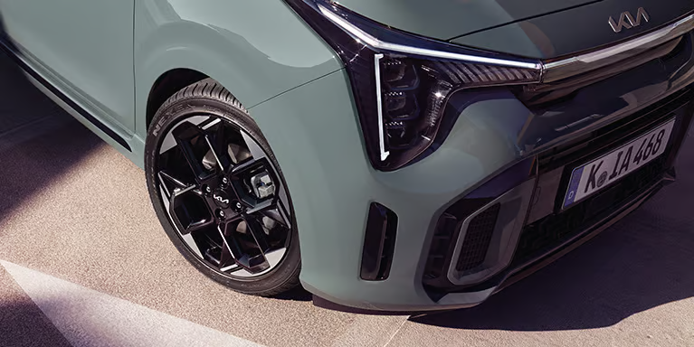 Ausschnitt eines Kia Picanto mit Fokus auf das Vorderrad und den Scheinwerfer.
