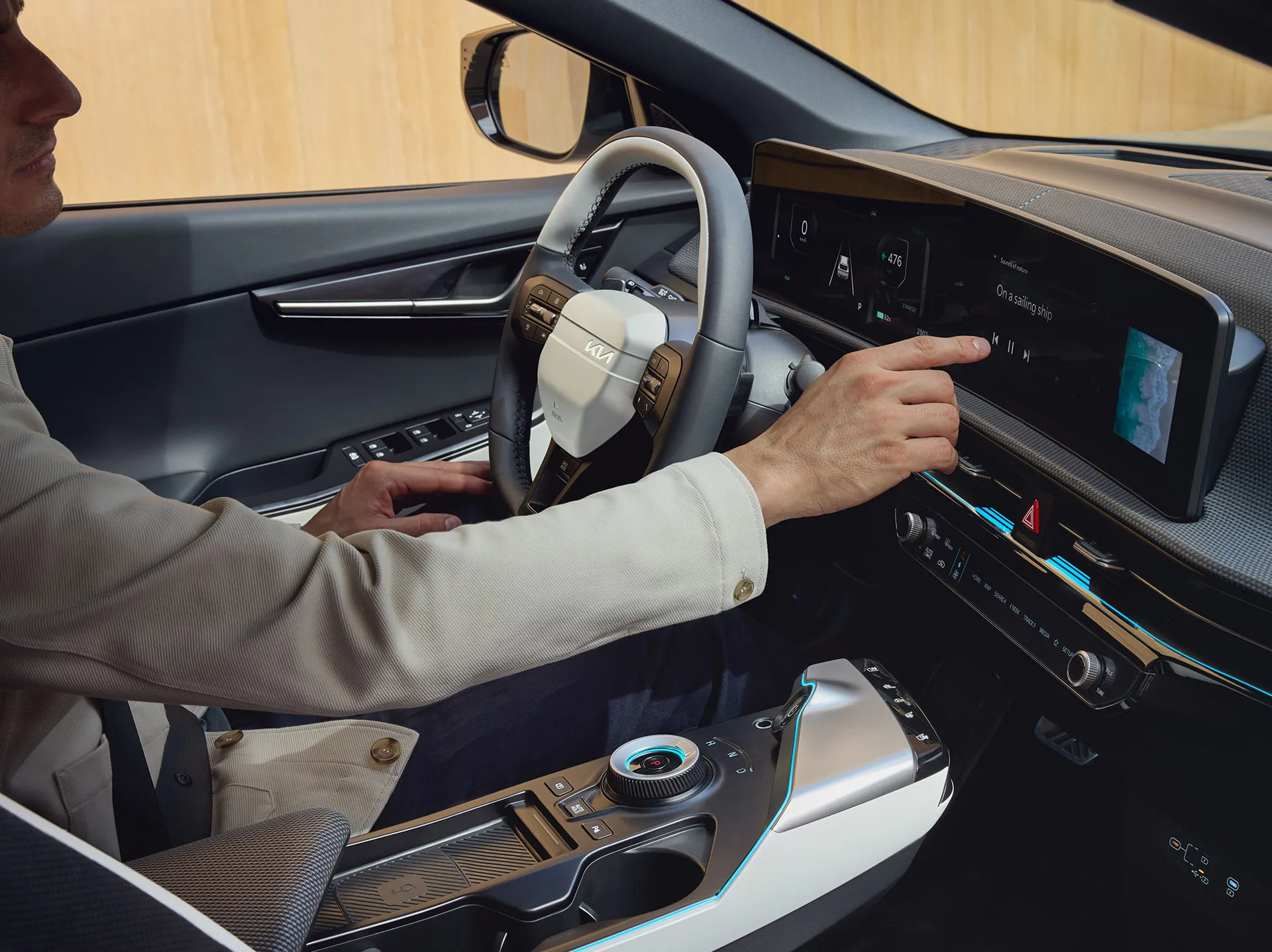 Person bedient den Touchscreen im Innenraum eines Kia EV6.