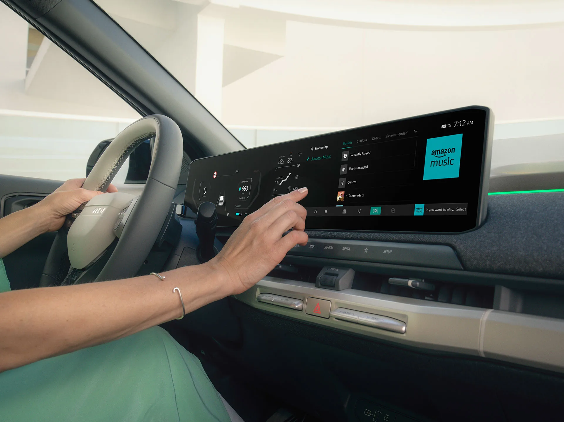 Person bedient den Touchscreen im Innenraum eines Kia-Fahrzeugs.