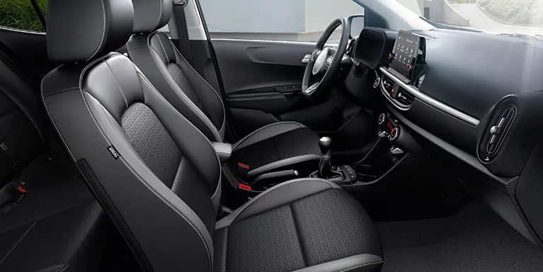 Innenraum eines Kia Picanto mit modernen schwarzen Sitzen und einem digitalen Armaturenbrett.