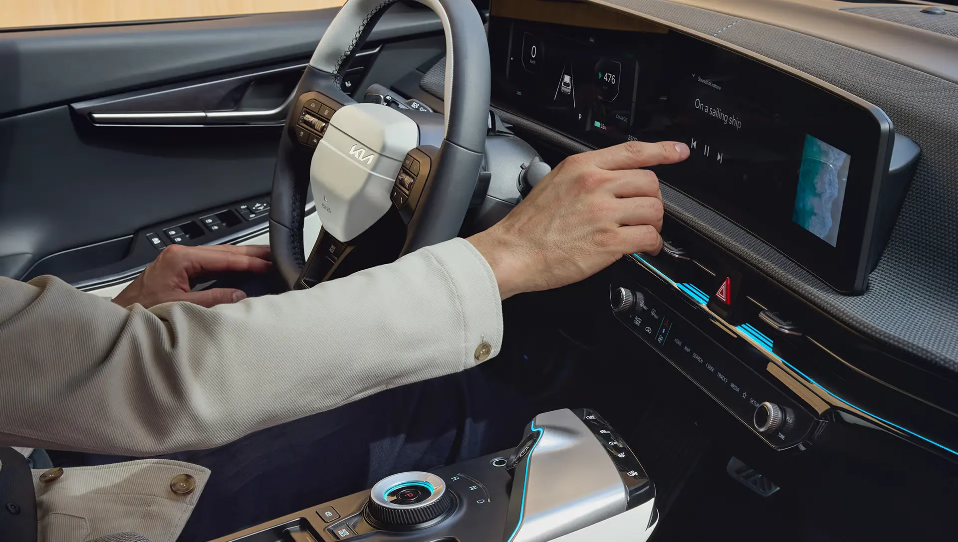 Eine Person bedient den Touchscreen im Innenraum eines Kia EV6.