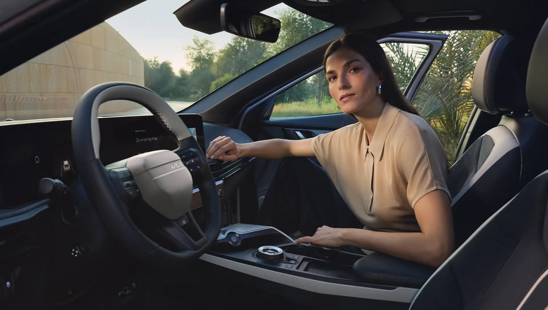 Eine Frau sitzt im Innenraum eines KIA EV6 und schaut zur Seite.