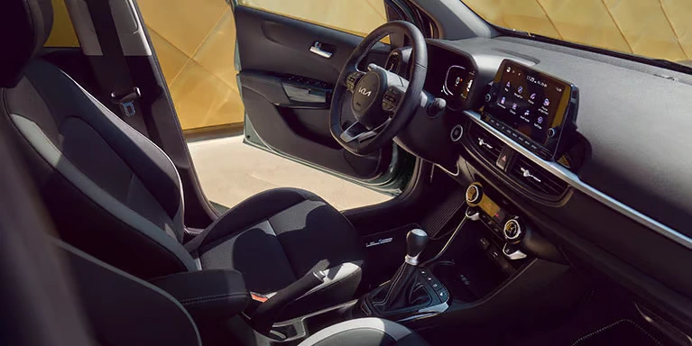 Innenraum eines Kia Picanto mit Lenkrad und Infotainment-Bildschirm.