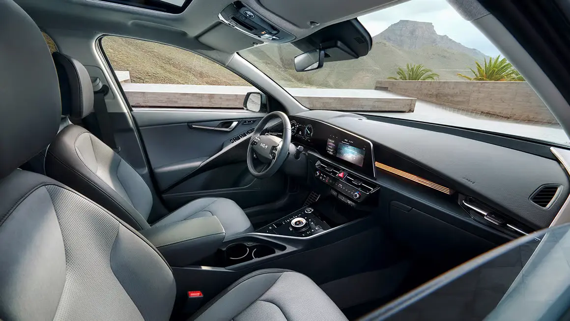 Kia Niro Innenraum mit digitalem Display, Lenkrad und Sitzen.