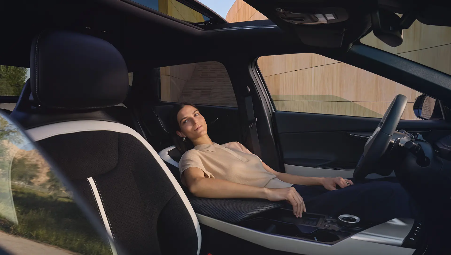 Frau entspannt sich auf dem Beifahrersitz eines Kia EV6 mit zurückgelehntem Sitz.