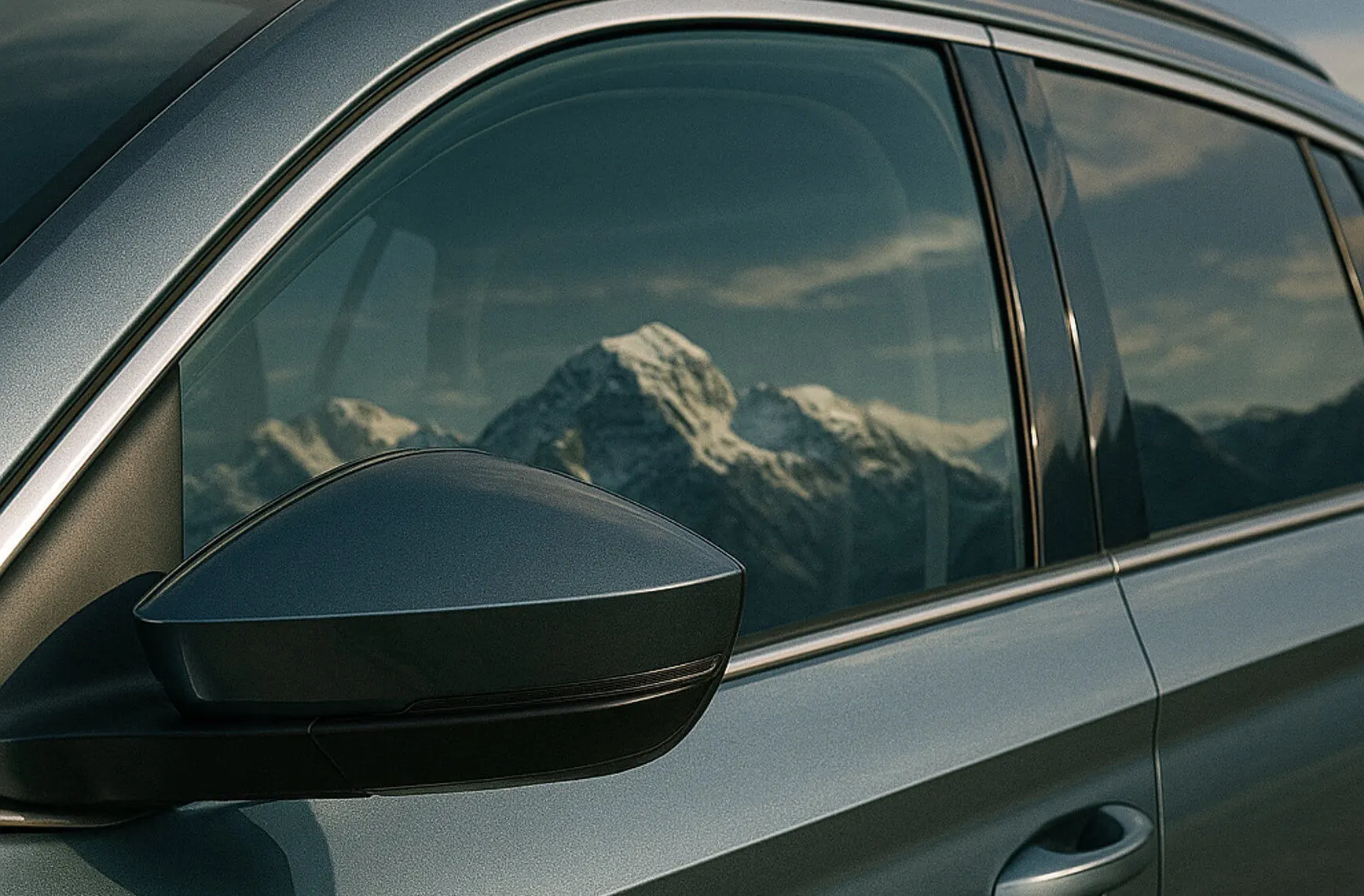 Nahaufnahme eines Autospiegels mit Berglandschaft im Hintergrund.