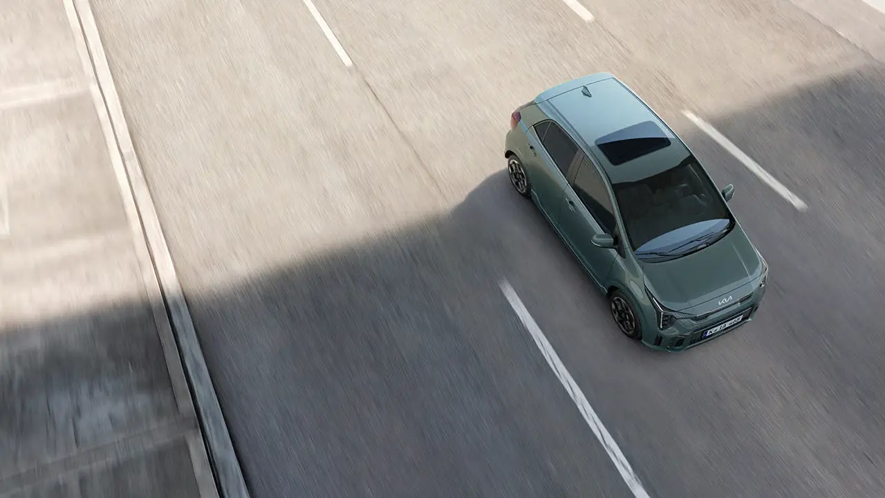 Ein grüner Kia Picanto fährt auf einer Straße.