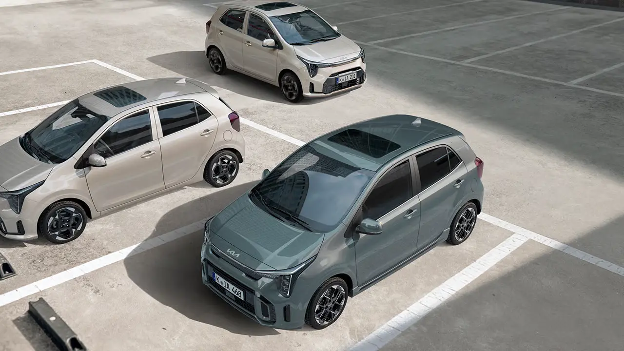 Drei Kia Picanto Autos stehen in einem leeren Parkplatz.