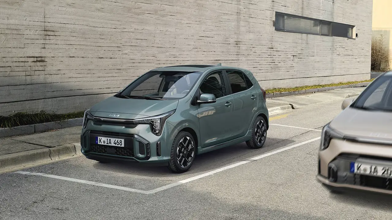 Ein grüner Kia Picanto GTL steht auf einem Parkplatz vor einer Betonwand.