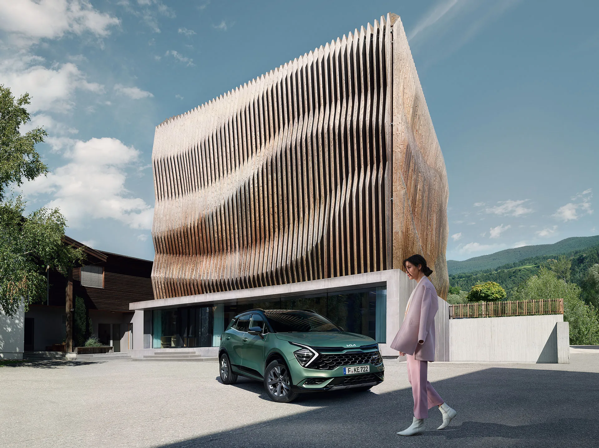 Eine Frau geht an einem grünen Kia Sportage vor einem modernen Gebäude vorbei.