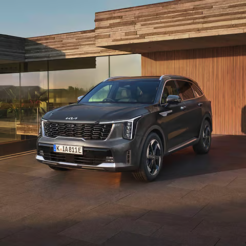KIA Sorento PHEV steht auf einer Terrasse vor einem modernen Gebäude.